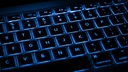 Black keyboard with blue backlighting between keys